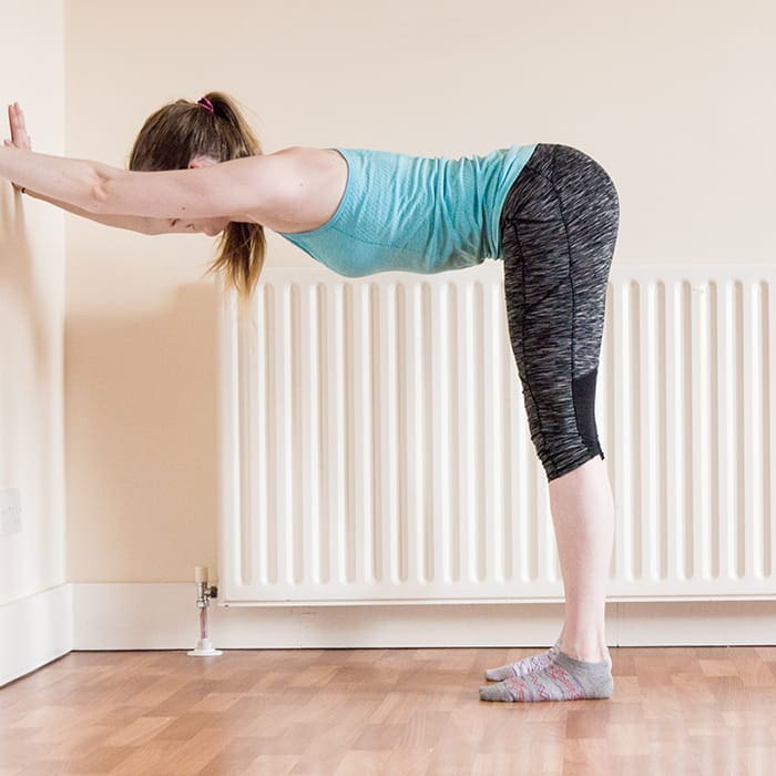 Use the wall to keep your spine straight. Walk you hands down as you get more flexible.