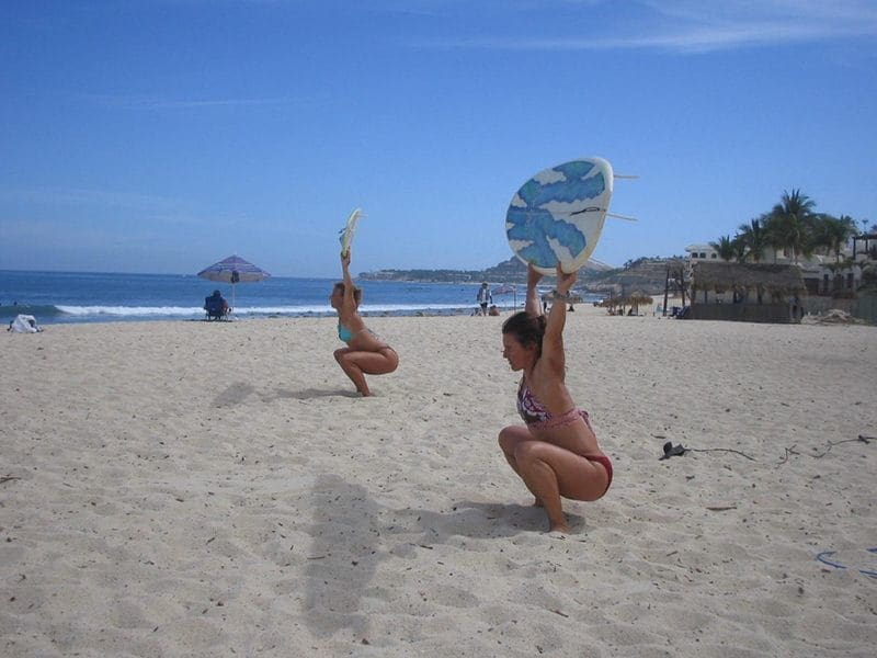 two surfer girls overhead squats holiday wods