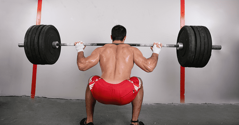 male crossfit athlete squatting 1rm