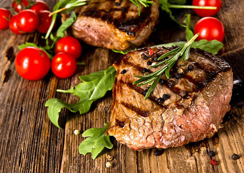 beef steak paleo bbq with tomatoes on wooden board