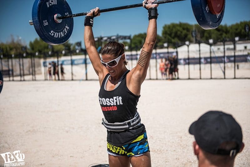 weightlifting woman works out on beach