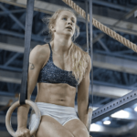 crossfit female performs ring muscle up