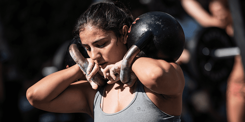 female athlete crossfit training kettlebells