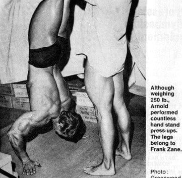Arnold performs bodybuilding pressing exercises like the handstand push up