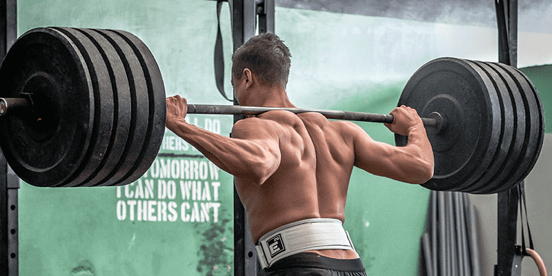 man using weightlifting belt on heavy squat