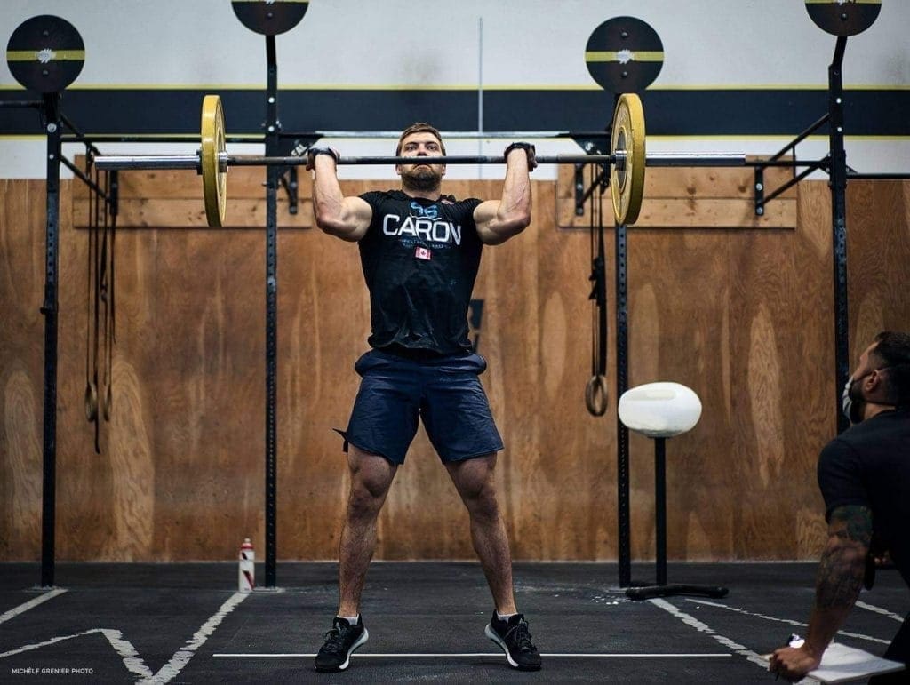 athlete uses push jerk to bring barbell overhead at 2020 crossfit games