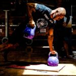 man performs hard kettlebell workout with gorilla cleans Kettlebell Exercises for Building Muscle