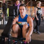 member of LGBTQ+ nonprofit the OUT Foundation does workout with support in the background