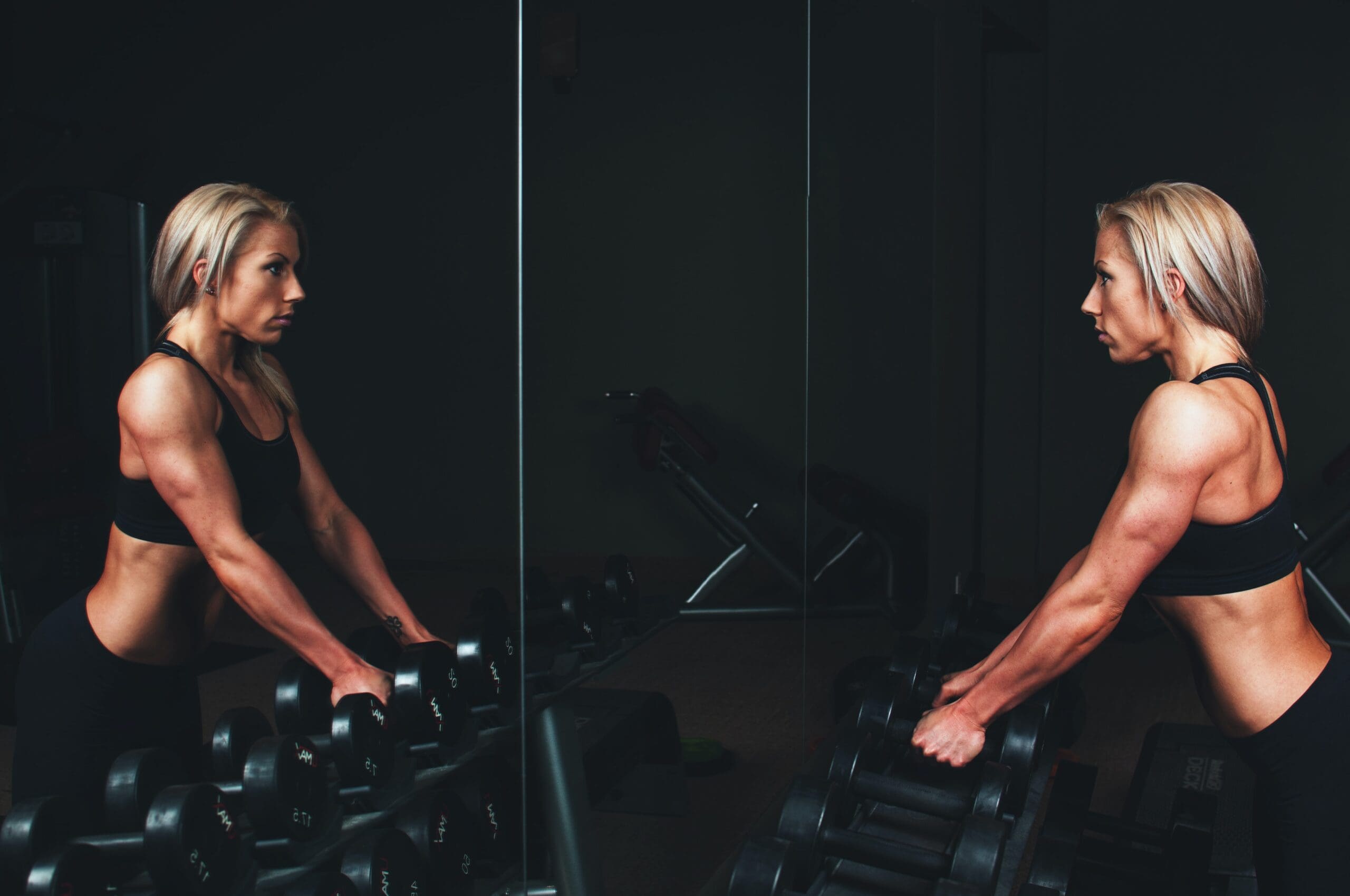 woman readies to perform dumbbell shrugs