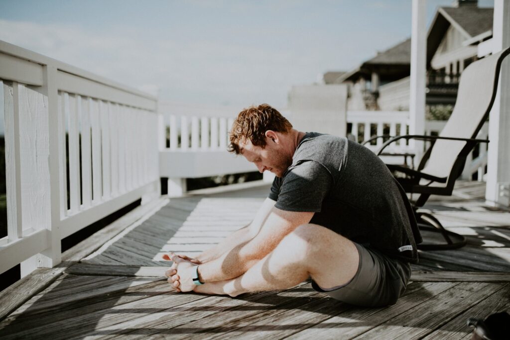 man performs glute stretches after run