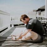 man performs glute stretches after run