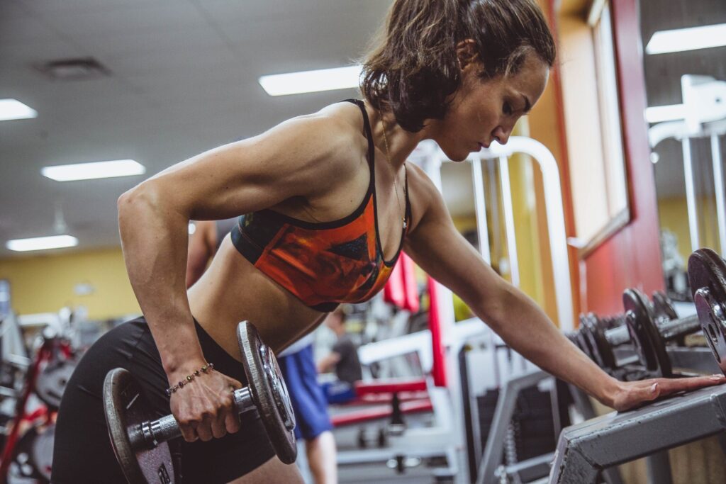 woman trains with dumbbell to grow muscle