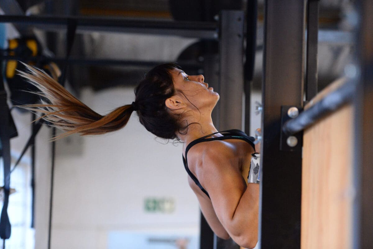 woman performs chest to bar pull up