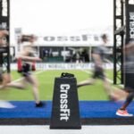 crossfit logo with team athletes running in blurred background