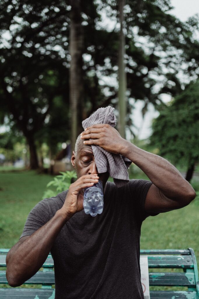 tired athlete holds towel to forehead