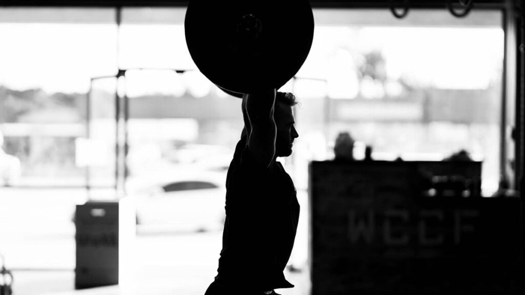 man lifting weight in garage gym