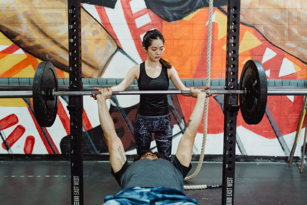 man trains to get a stronger bench press with spotter