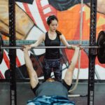 man trains to get a stronger bench press with spotter