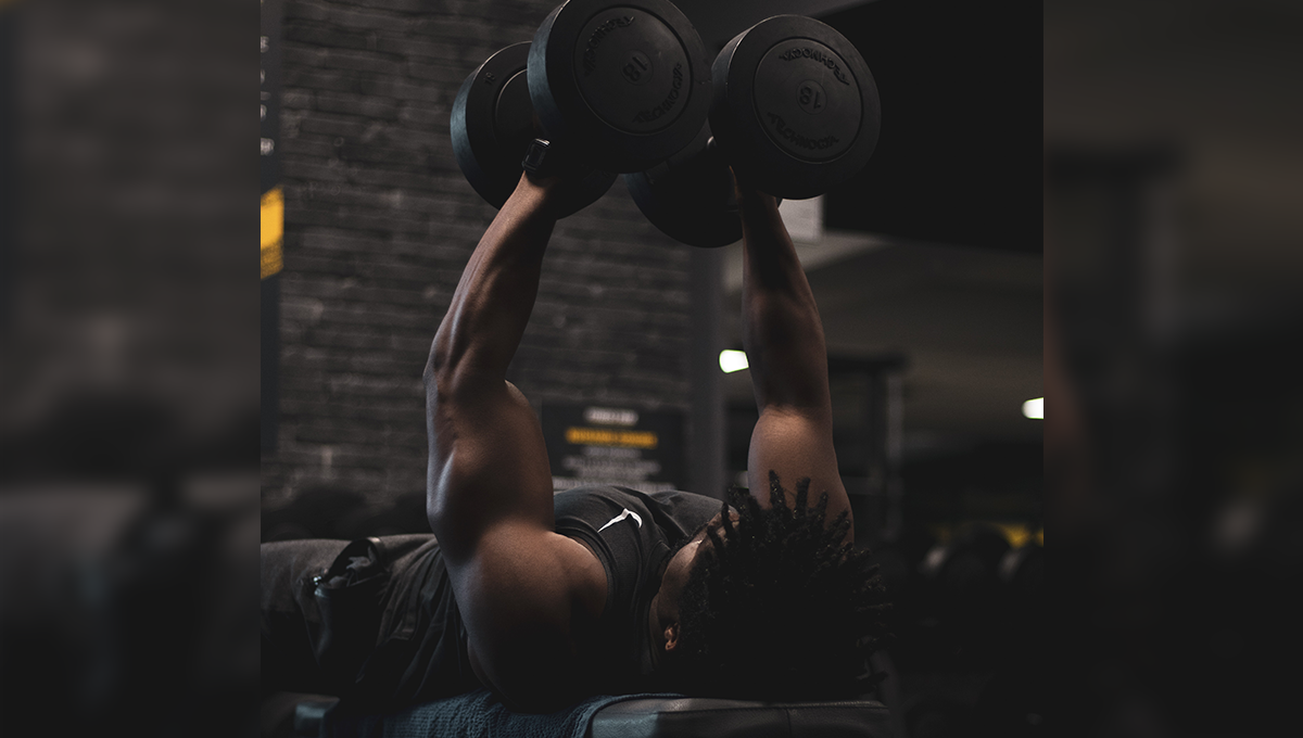 man performs effective shoulder exercise with dumbbells