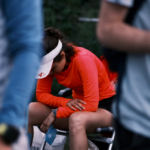 athlete sitting on chair facing down faces discomfort after long race