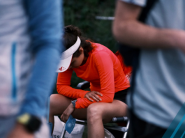 athlete sitting on chair facing down faces discomfort after long race