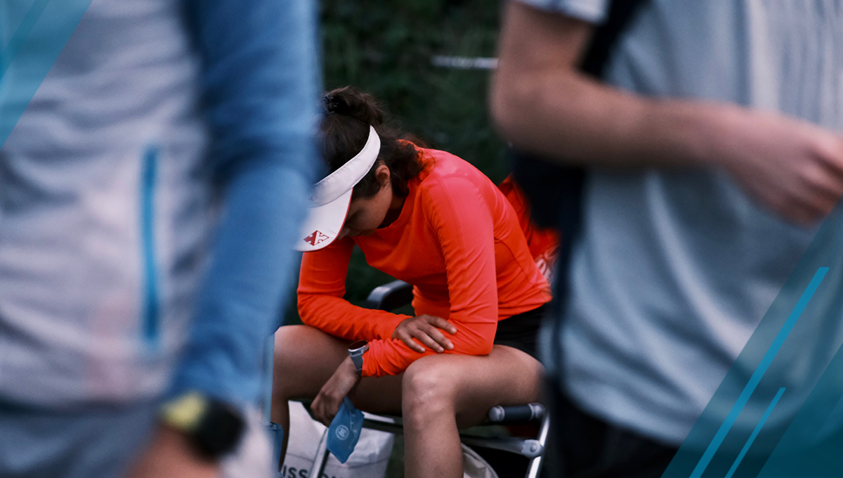 athlete sitting on chair facing down faces discomfort after long race