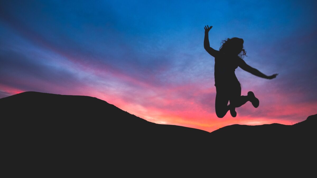 learn how to fix your circadian rhythm like this woman who is jumping into the sunset full of energy