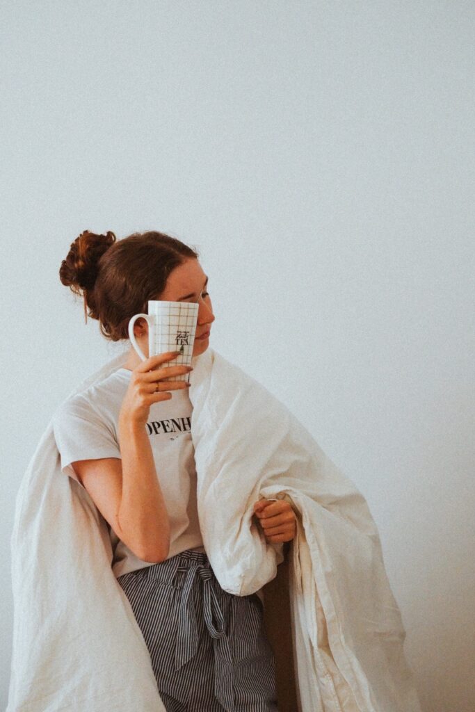 tired woman takes duvet into work with coffee