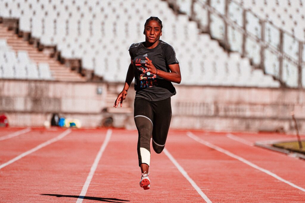 Women Running On Athletic Track by Jupiterimages