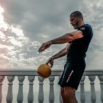 man performs kettlebell workout with single kettlebell