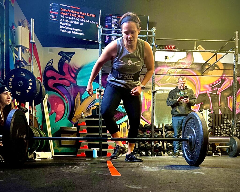 athlete performs burpee over bar