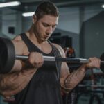 man in gym doing a barbell curl
